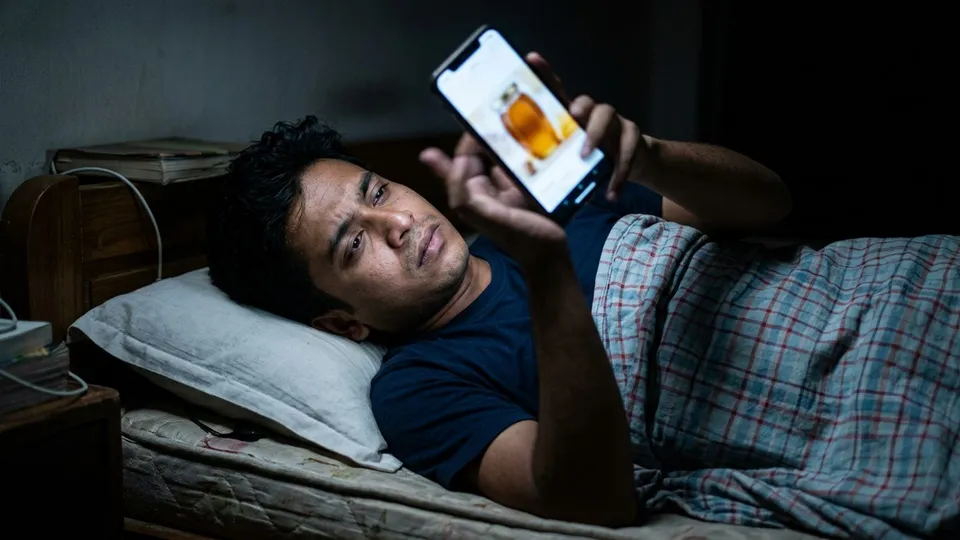 একজন যুবক রাতে বিছানায় শুয়ে ফোন স্ক্রল করছেন, ফোনের ফিডে একই মধুর বোতলের অ্যাড আবার এসেছে, তাঁর মুখে বিরক্তি আর আঙুল ওপরের দিকে সরানো